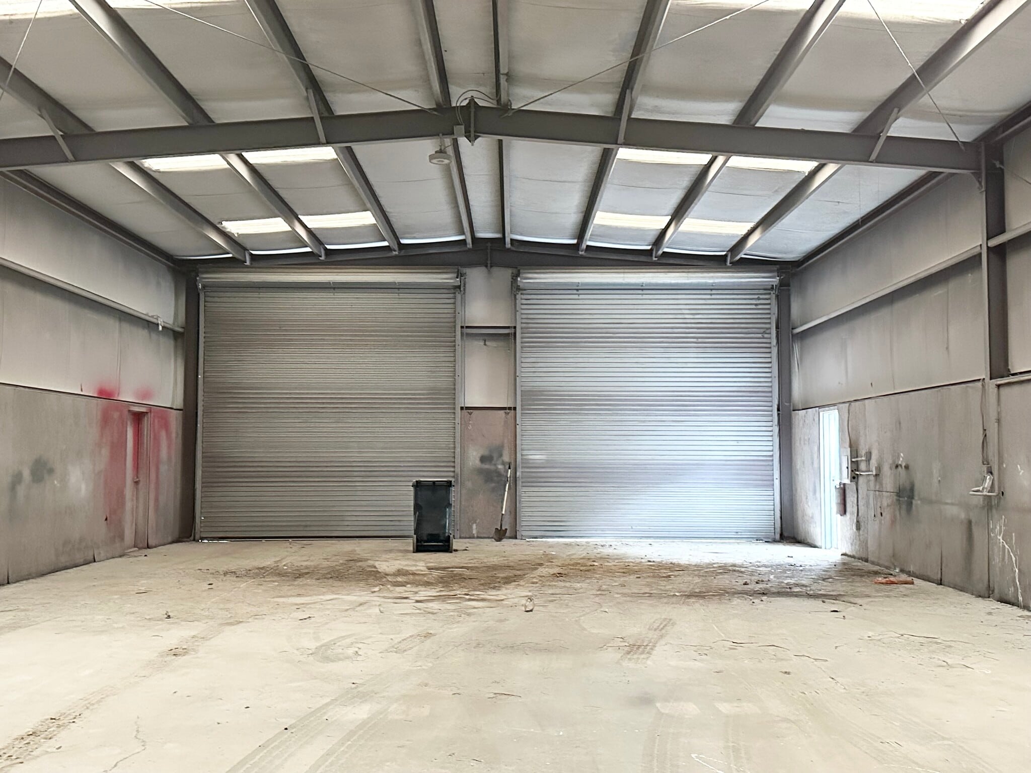 Warehouse interior with two grade-level roll-up doors at 13626 Ann Louise Rd