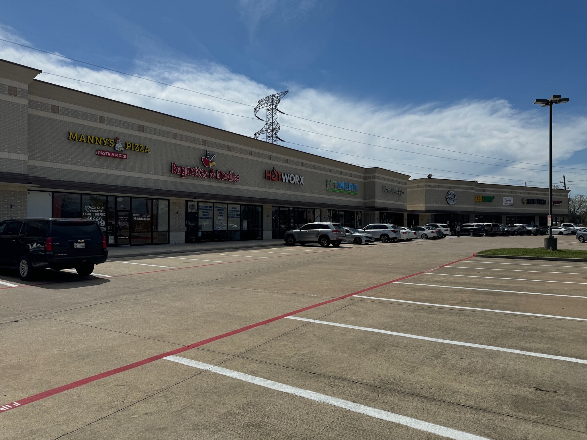 Curved retail center facade with tenant entrances and parking