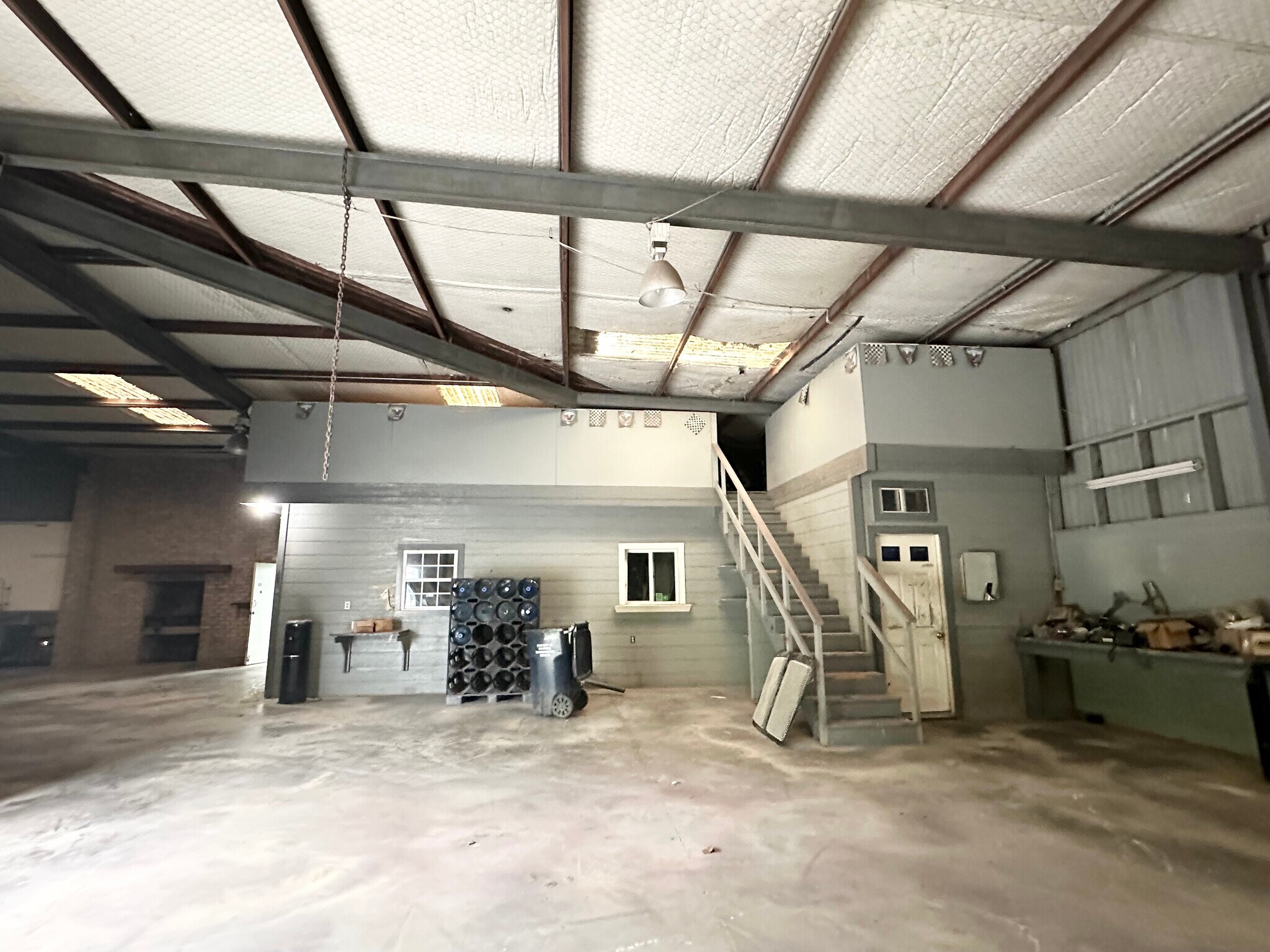 Main warehouse interior with office structure and mezzanine stairs at 13626 Ann Louise Rd