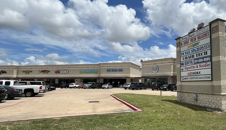 Shopping center entrance with monument sign and storefront visibility
