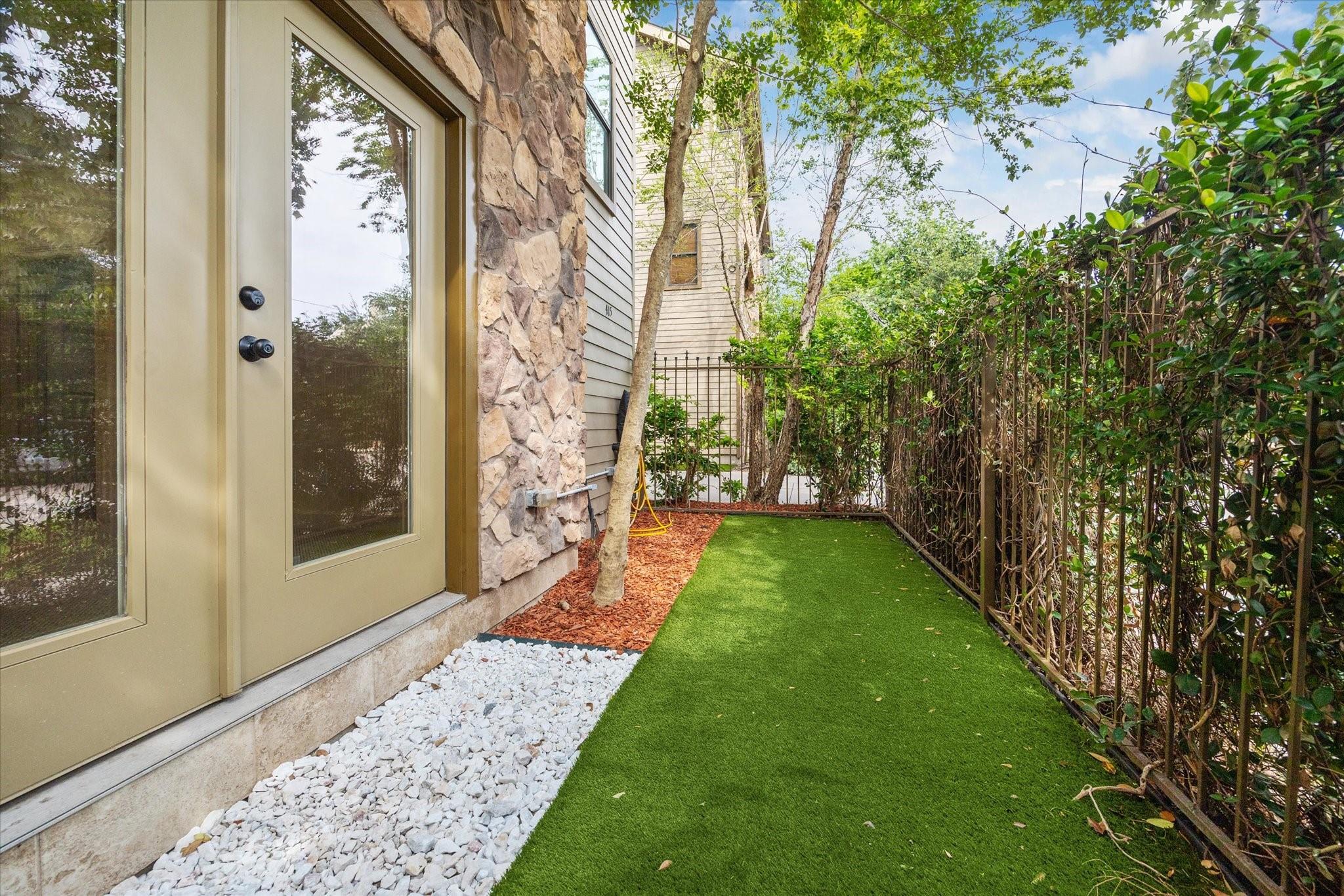 Private fenced side yard with artificial turf at 415 Tuam Street