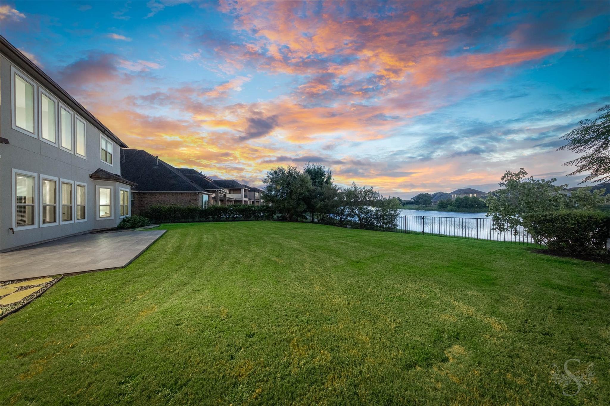 Oversized backyard with covered patio and lake views at 5026 Quiet Falls Lane