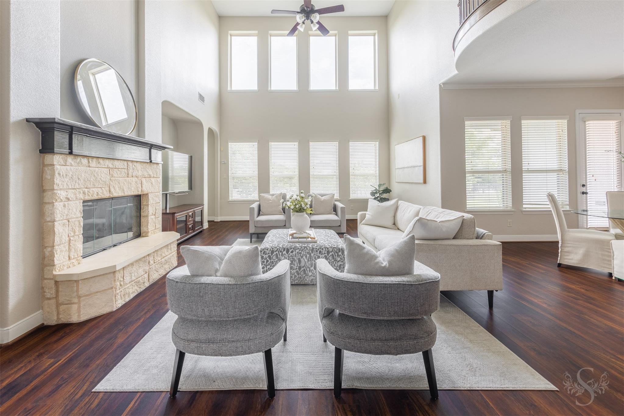 Two-story family room with stone fireplace and lake views at 5026 Quiet Falls Lane