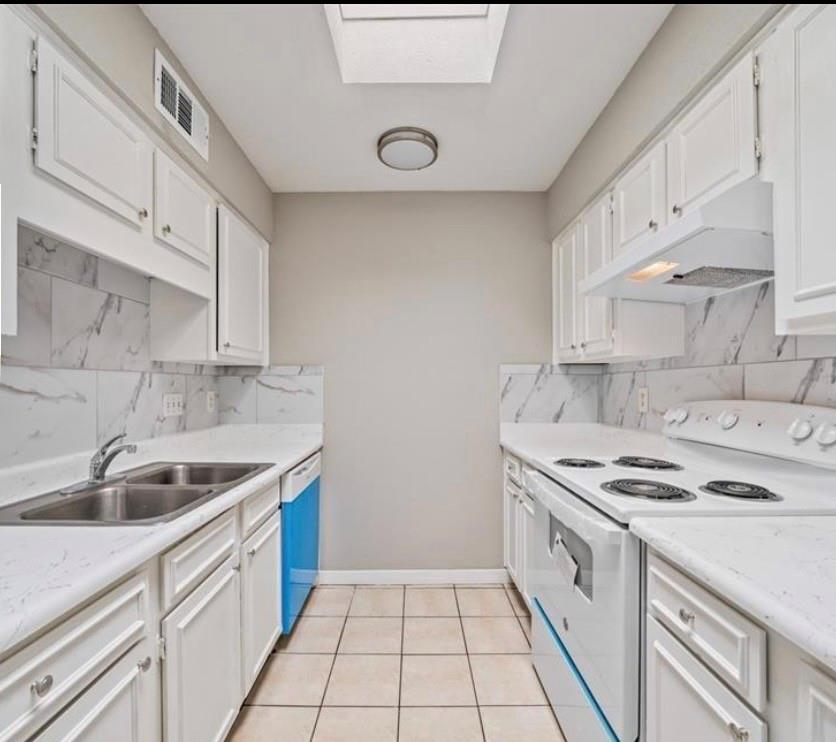 Kitchen with white cabinetry and electric range