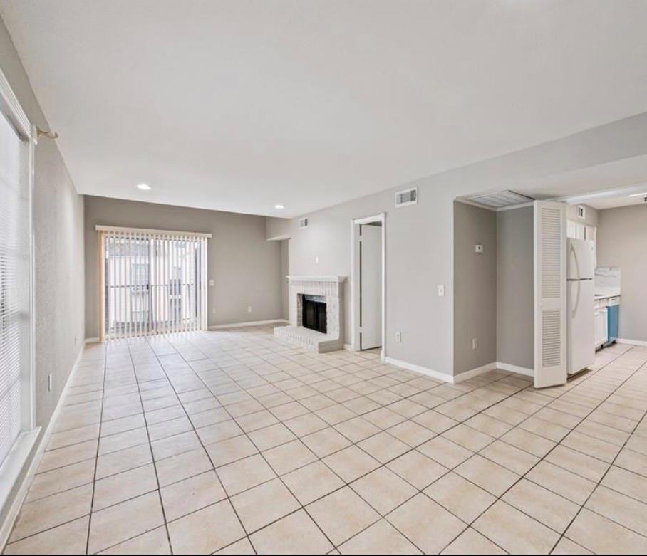 Unfurnished living room with fireplace and tile flooring