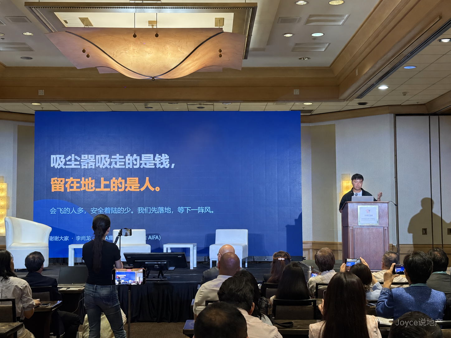 李尚龙演讲结尾PPT写着吸尘器吸走的是钱、留在地上的是人,右下角带“Joyce说地产”暗标