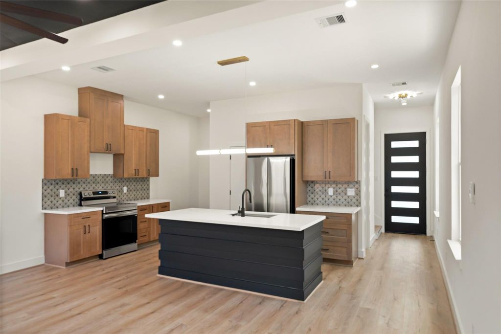 Unit A kitchen with quartz island and wood cabinetry | A单元配石英岛台和木色橱柜的厨房