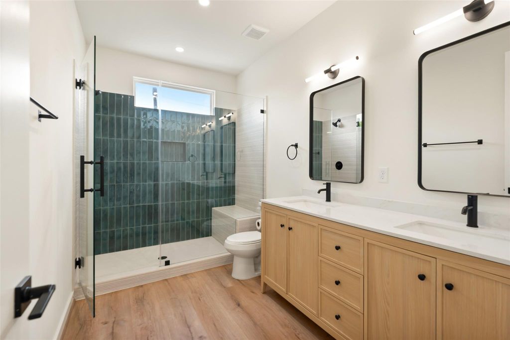 Unit A bathroom with tiled glass shower and light wood vanity | A单元带玻璃瓷砖淋浴间和浅木浴室柜的卫生间