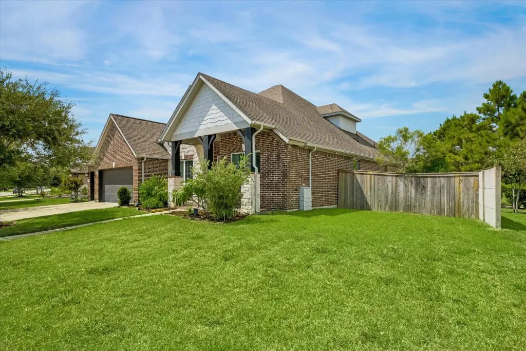 Side exterior, lawn and fenced yard of the Pearland home | Pearland住宅侧面、草坪和围栏庭院