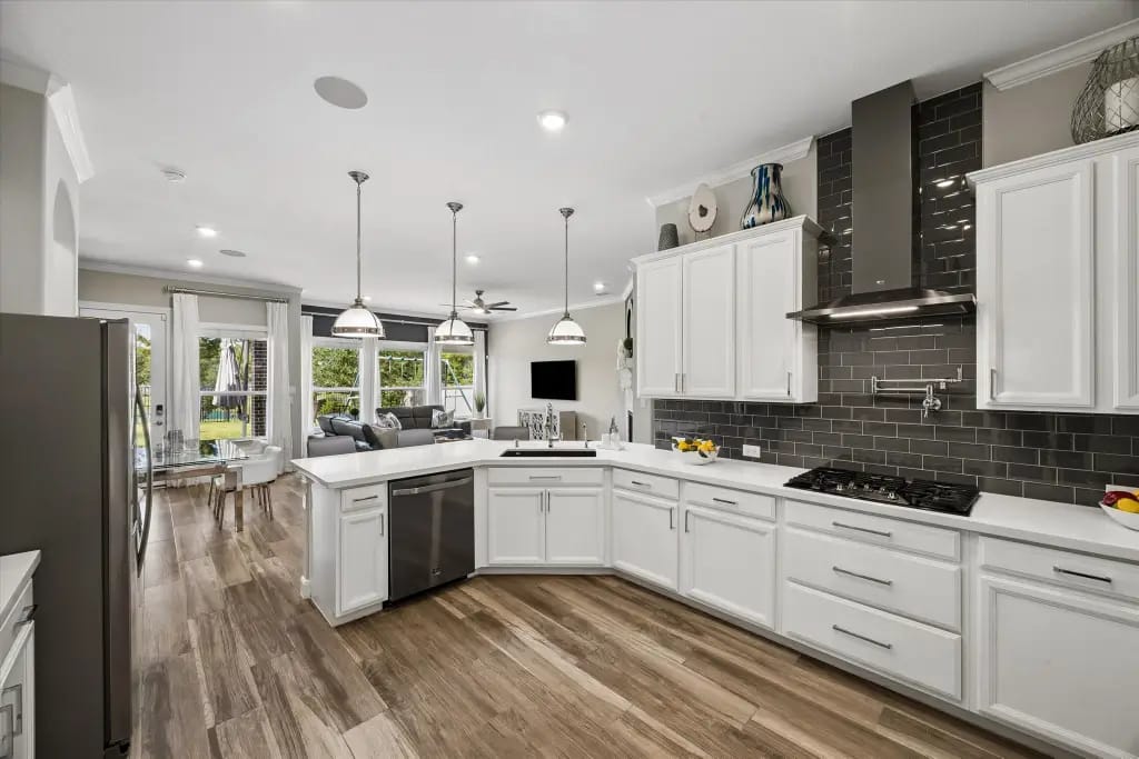 Open kitchen with white cabinetry, gas cooktop and black tile backsplash | 白色橱柜、燃气灶和黑色瓷砖后挡板的开放式厨房