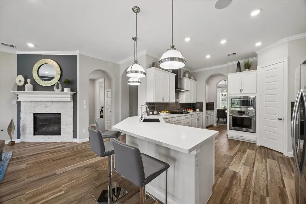 Kitchen island seating with the fireplace and living area beyond | 厨房岛台座位及相连的壁炉和客厅空间