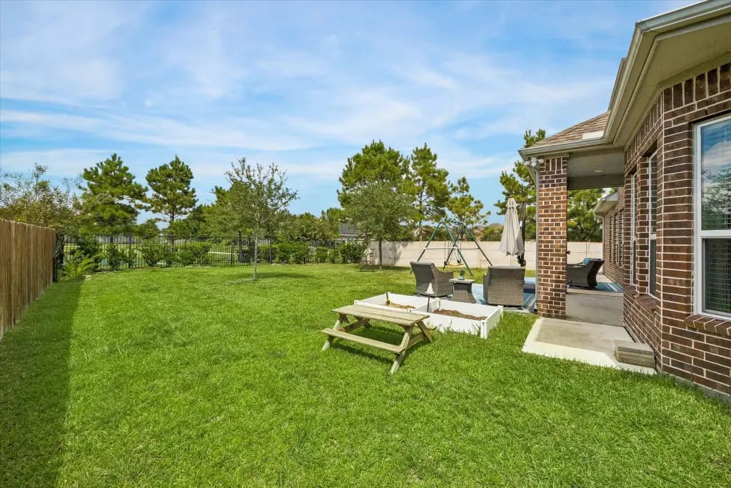 Fenced backyard, covered patio and open lawn beside the lake lot | 湖景地块旁的围栏后院、带顶露台和草坪