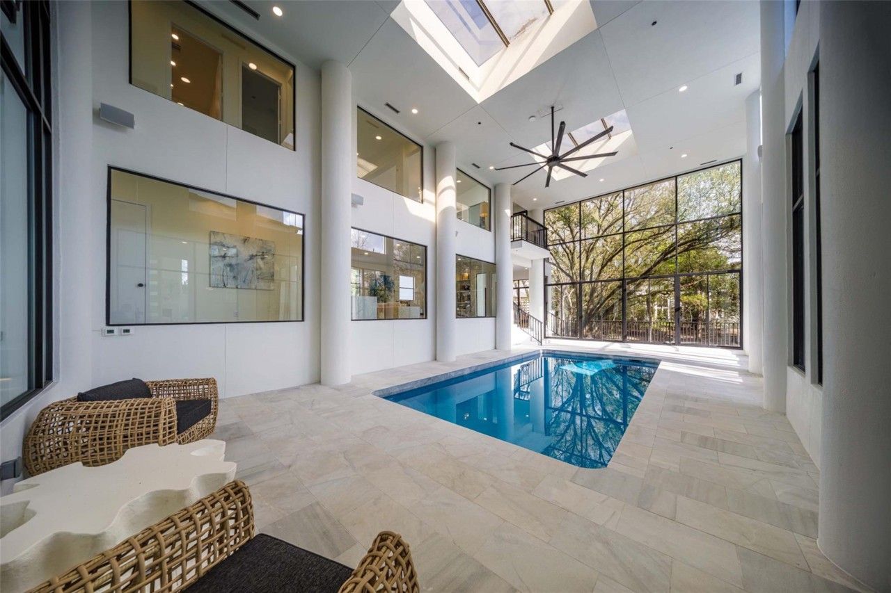 Glass-enclosed indoor pool with treetop views