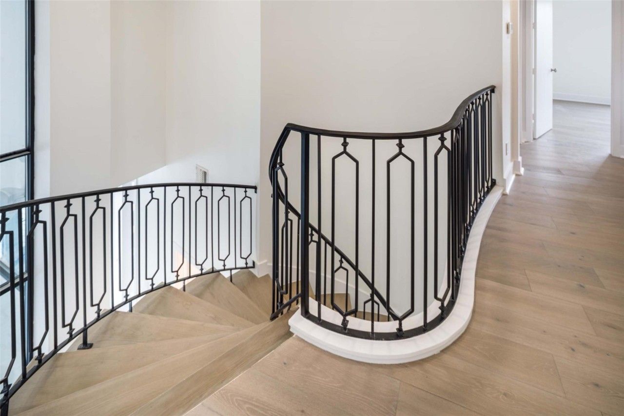 Modern staircase with curved landing and iron railing