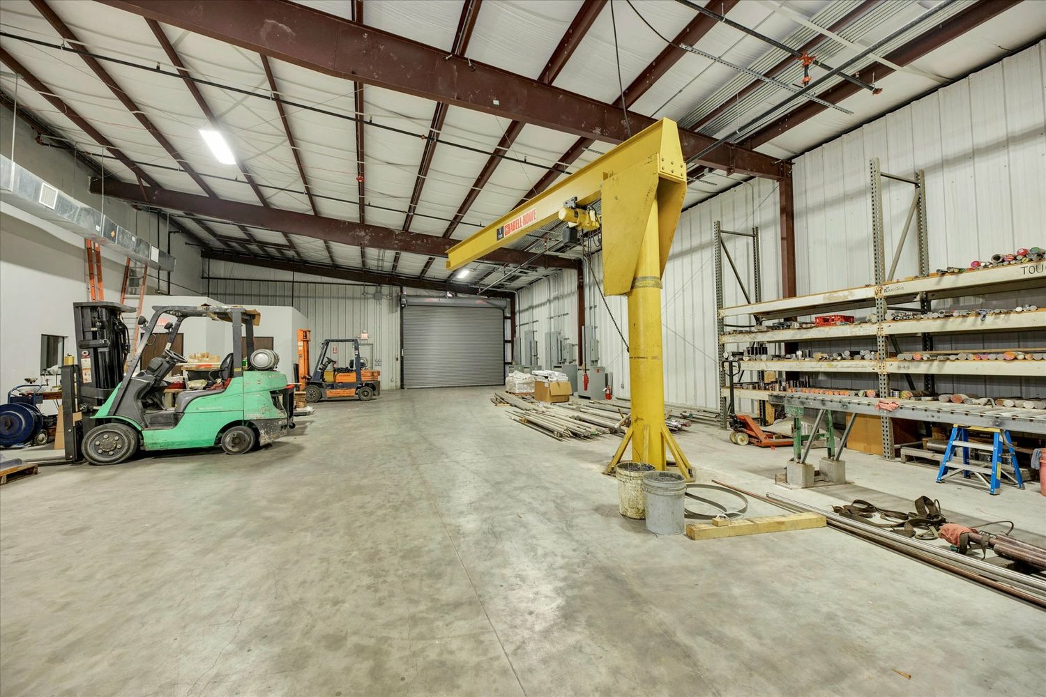 Warehouse loading area with crane and roll-up door / 带起重设备和卷帘门的仓储作业区