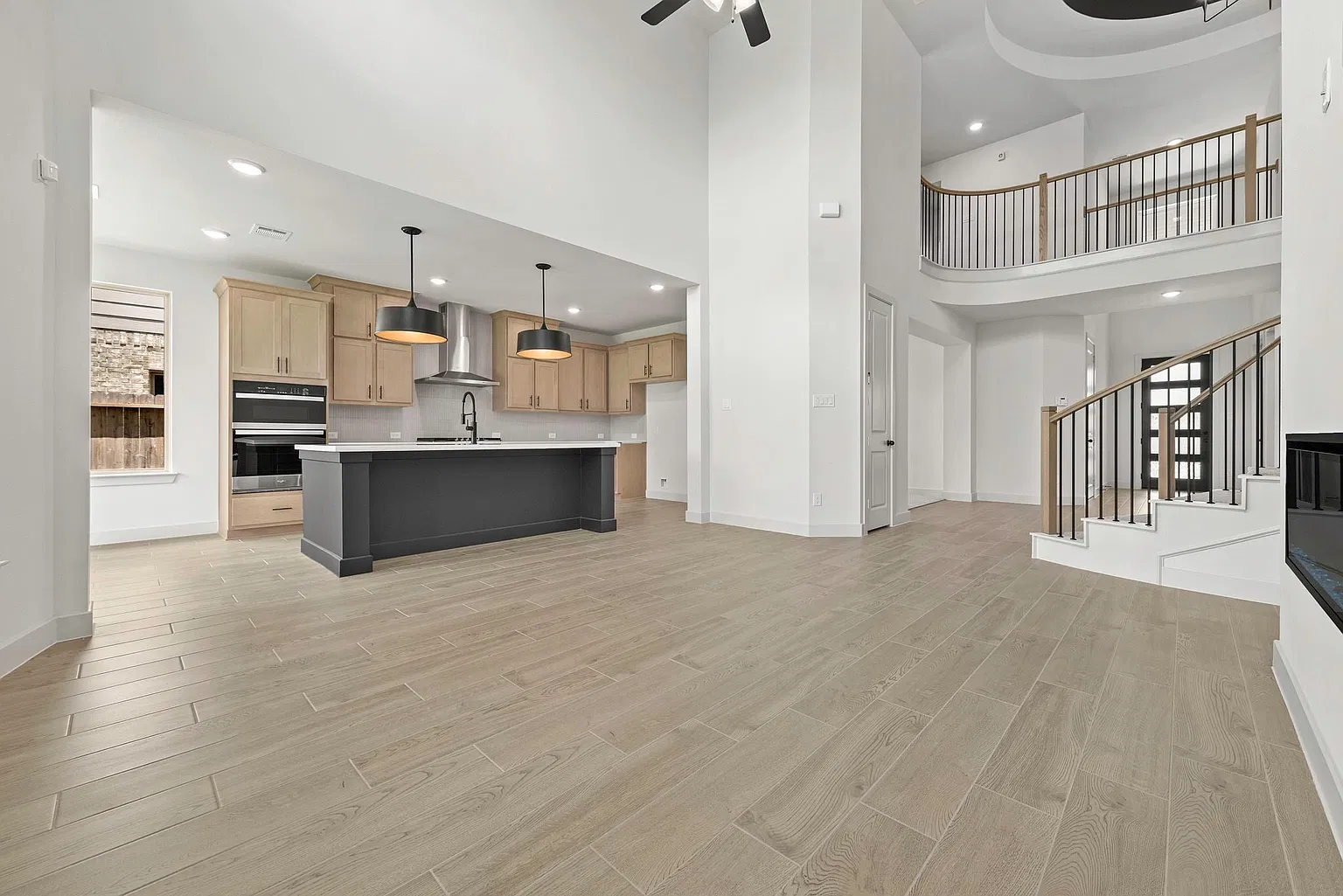 Open kitchen and family room with large island and high ceiling | 配大岛台和高挑空间的开放式厨房及家庭厅