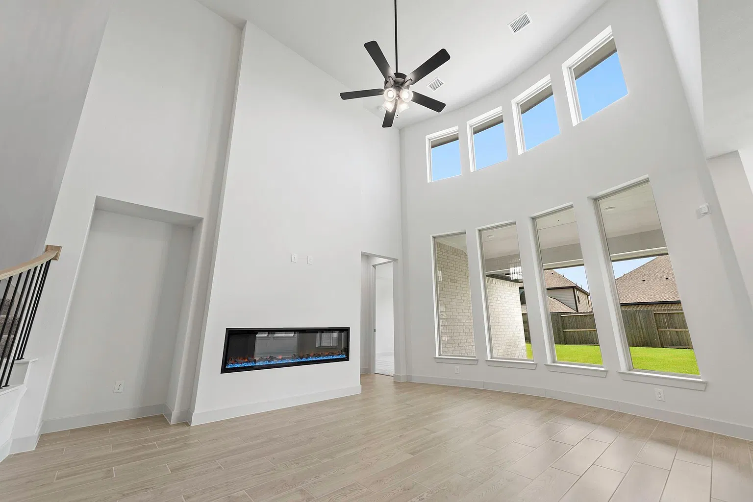 Two-story family room with electric fireplace and backyard windows | 配电壁炉和后院采光窗的挑高家庭厅