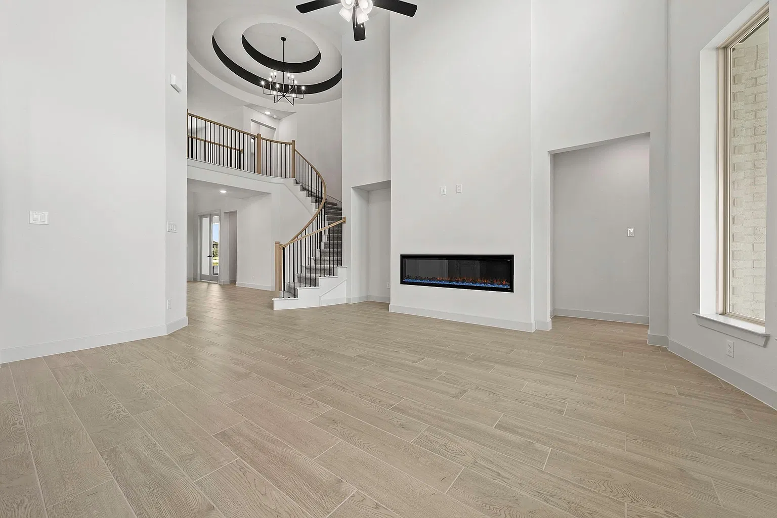 Family room fireplace viewed toward the curved staircase | 从家庭厅电壁炉看向弧形楼梯