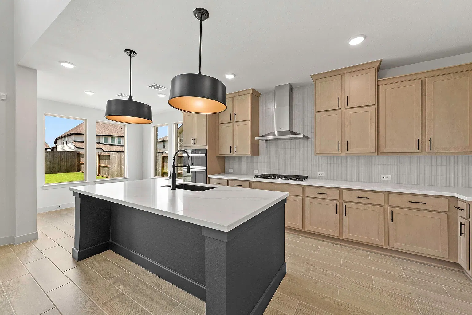 Island kitchen with quartz counters, light wood cabinets and black accents | 配石英台面、浅木橱柜和黑色细节的岛台厨房
