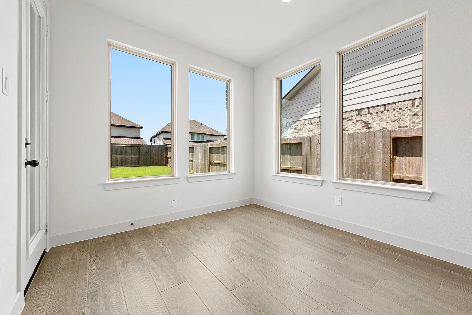 First-floor study with three windows and wood-look tile floor | 带三扇窗和木纹地砖的一楼书房