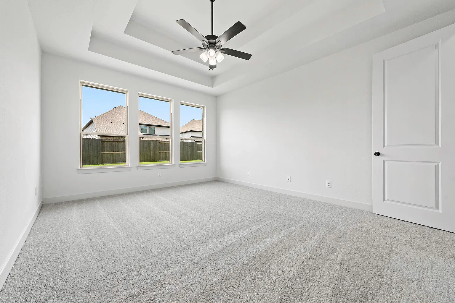 First-floor primary bedroom with tray ceiling and backyard windows | 配造型顶和后院采光窗的一楼主卧