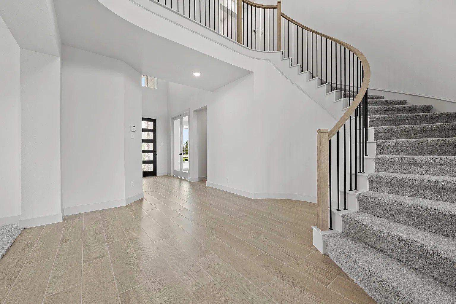 First-floor hall and curved staircase viewed from the living area | 从公共空间看一楼走廊和弧形楼梯