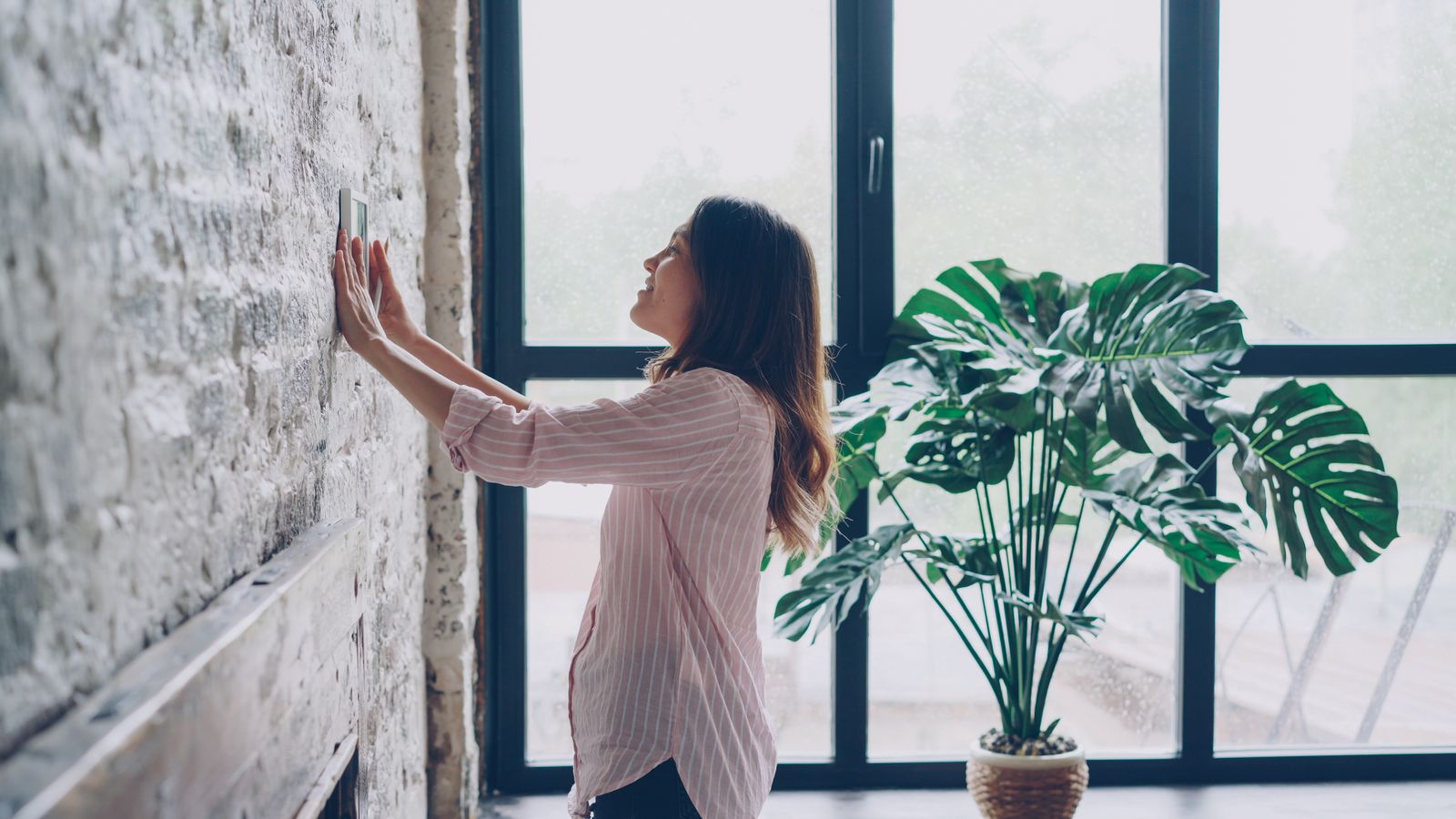Homeowner checking a wall thermostat before deciding whether to repair or replace the air-conditioning system / 房主查看墙上恒温器，准备判断空调应维修还是更换