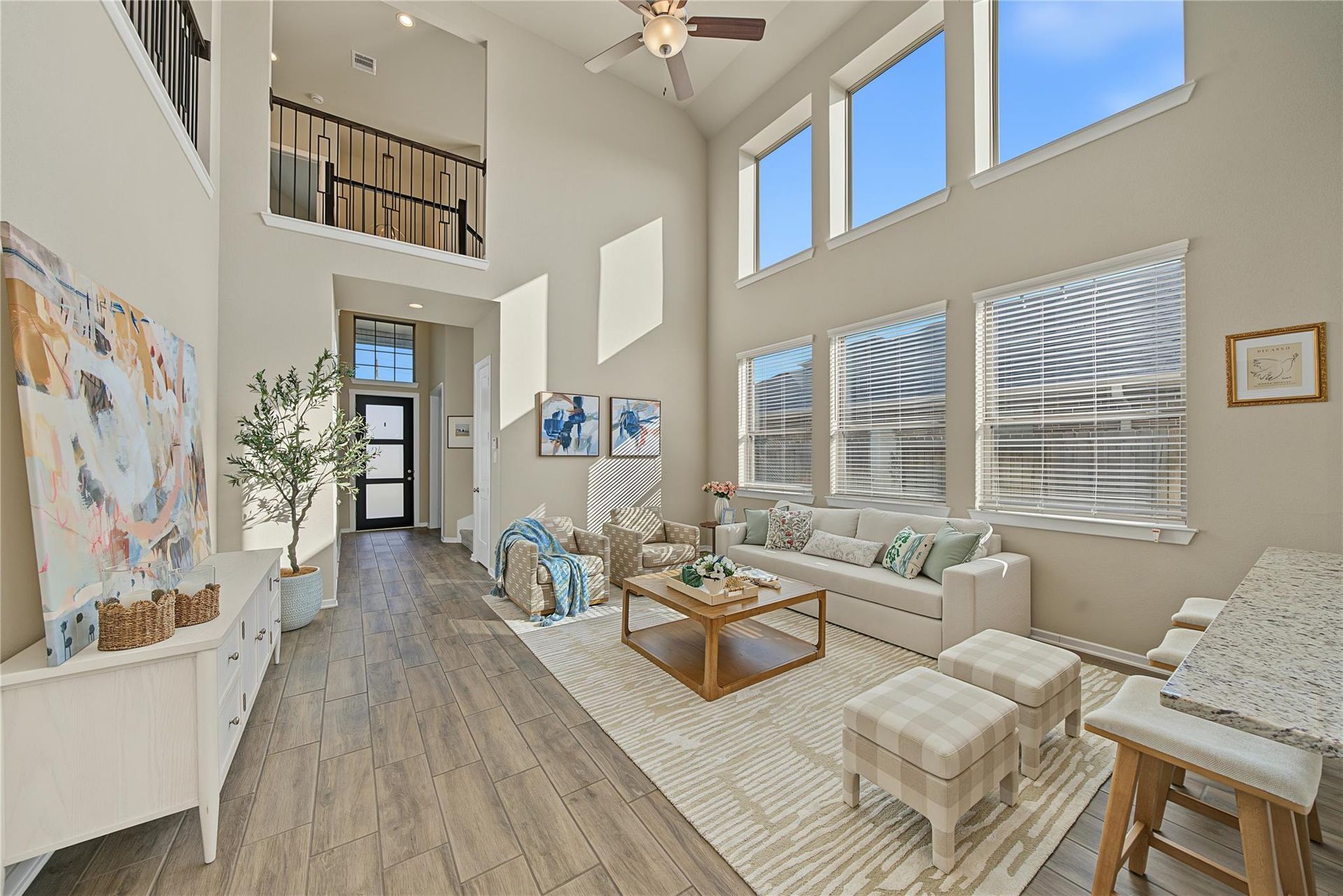 Family room viewed toward the foyer and upstairs railing | 客厅看向门厅和二楼栏杆