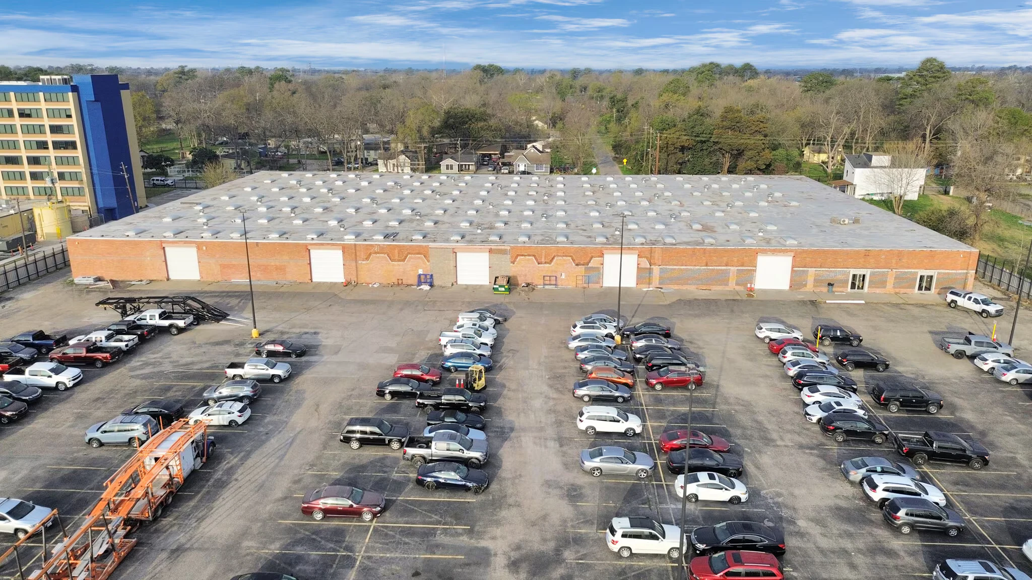 Front aerial showing the long industrial building and vehicle yard at 9001 Jensen Dr | 9001 Jensen Dr长条工业建筑及车辆场地正面航拍
