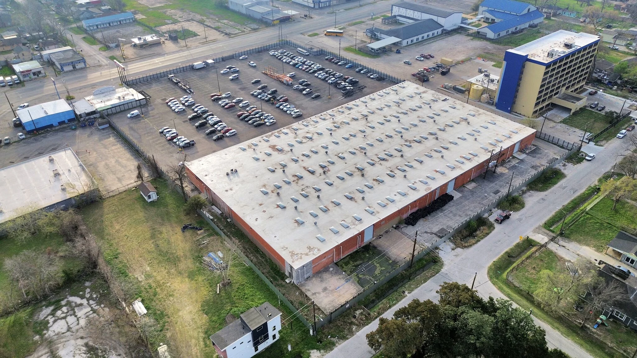 Oblique aerial showing the warehouse roof, paved yard and surrounding properties | 显示仓库屋顶、铺装场地及周边物业的斜角航拍