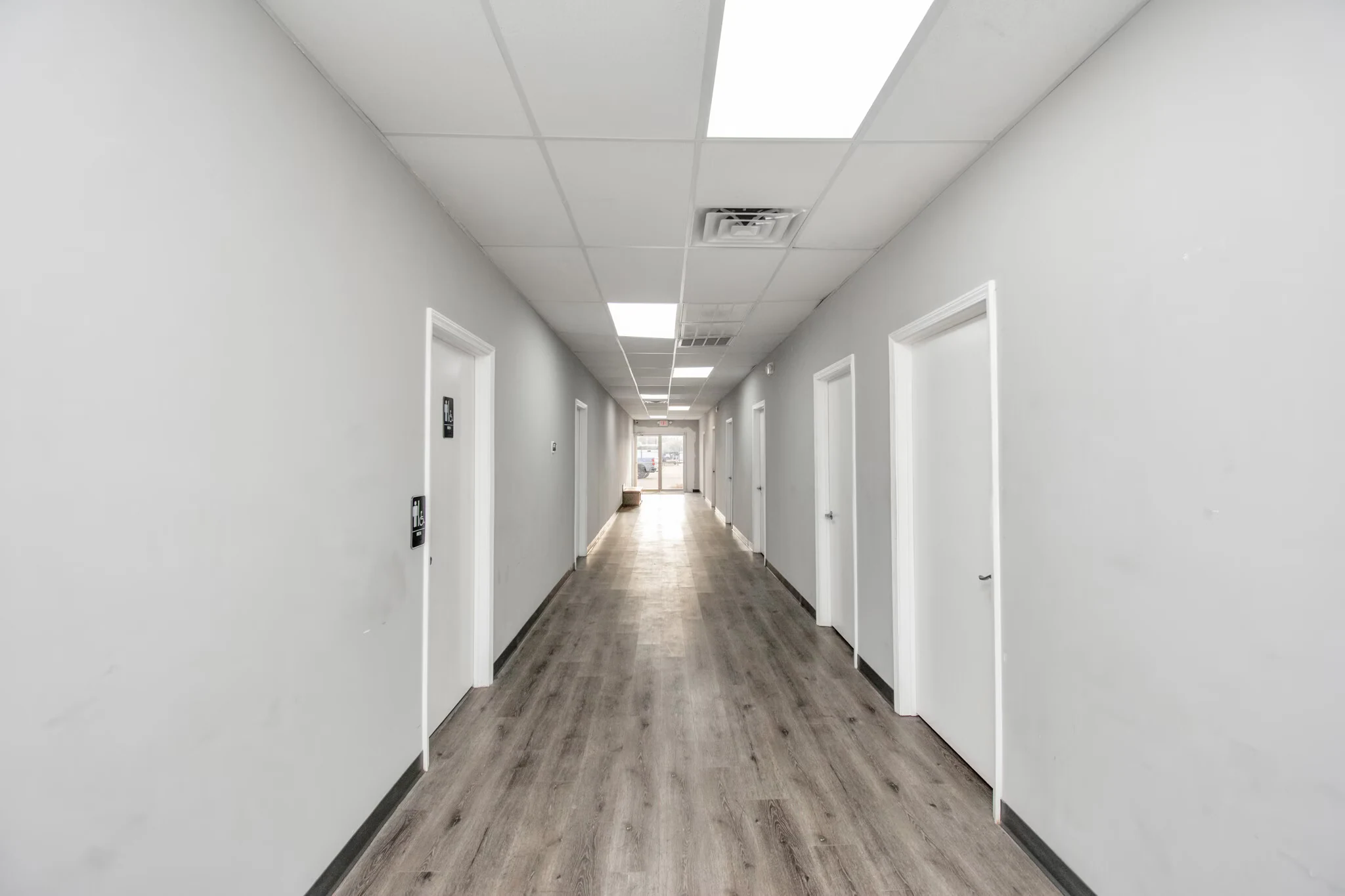 Long interior office corridor with multiple doorways and overhead lighting | 带多处门口和顶灯的室内办公走廊