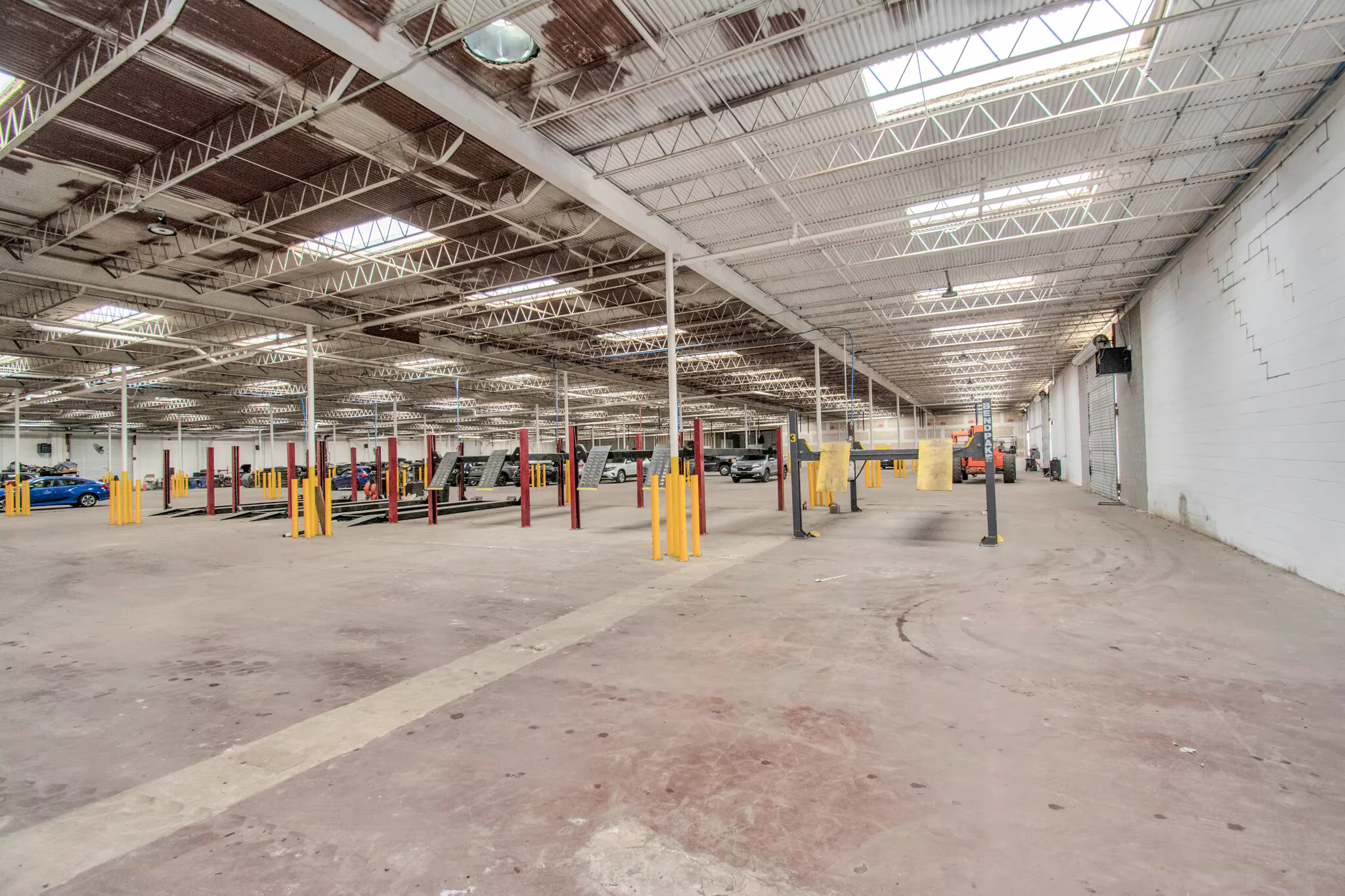 Long warehouse bay with skylights, columns and open circulation space | 带天窗、立柱及开放通行空间的长条仓库区域
