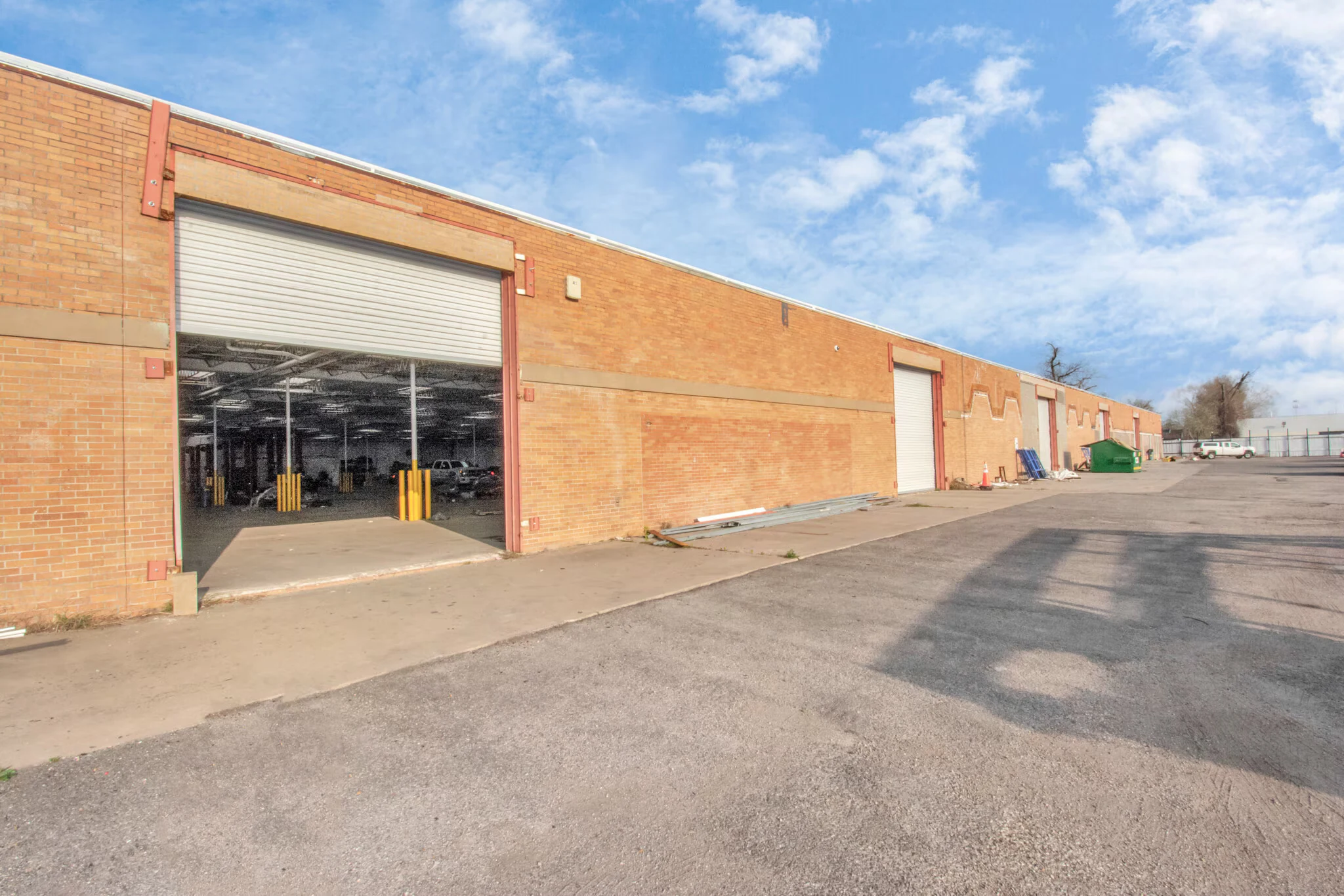 Brick warehouse exterior with a large grade-level drive-in door | 带大型地面卷门的砖结构仓库外观
