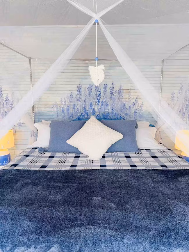 Spacious geodesic dome interior with bed, seating area and wide windows | 带睡眠区、休息区和大面积窗景的穹顶屋室内