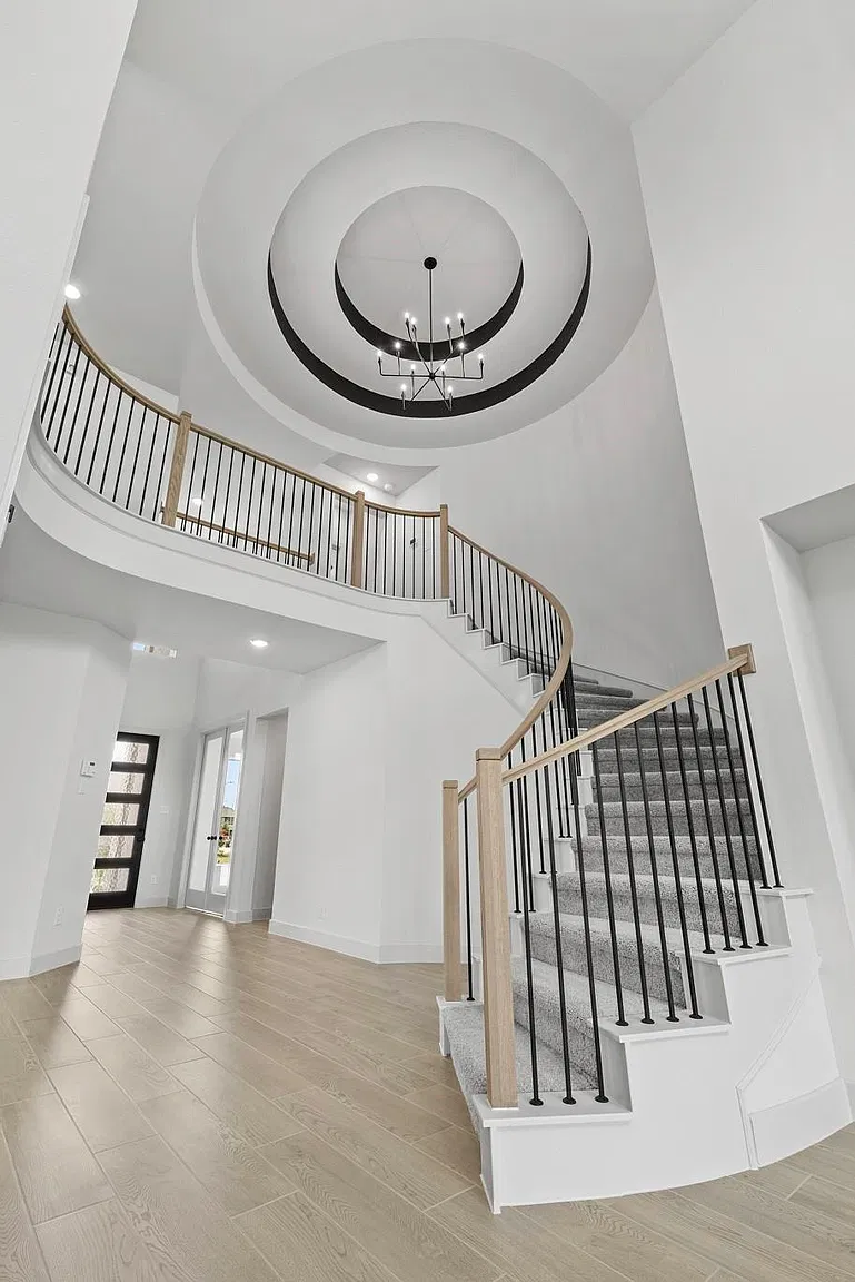 Two-story entry with curved staircase and circular ceiling detail | 带弧形楼梯和圆形挑高造型的门厅