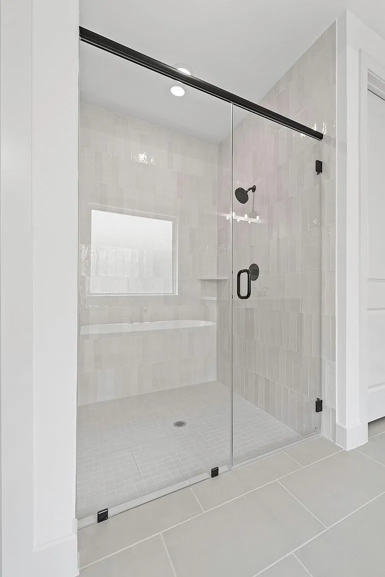 Glass-enclosed tiled shower in the primary bathroom | 主卫内玻璃围合的瓷砖淋浴间