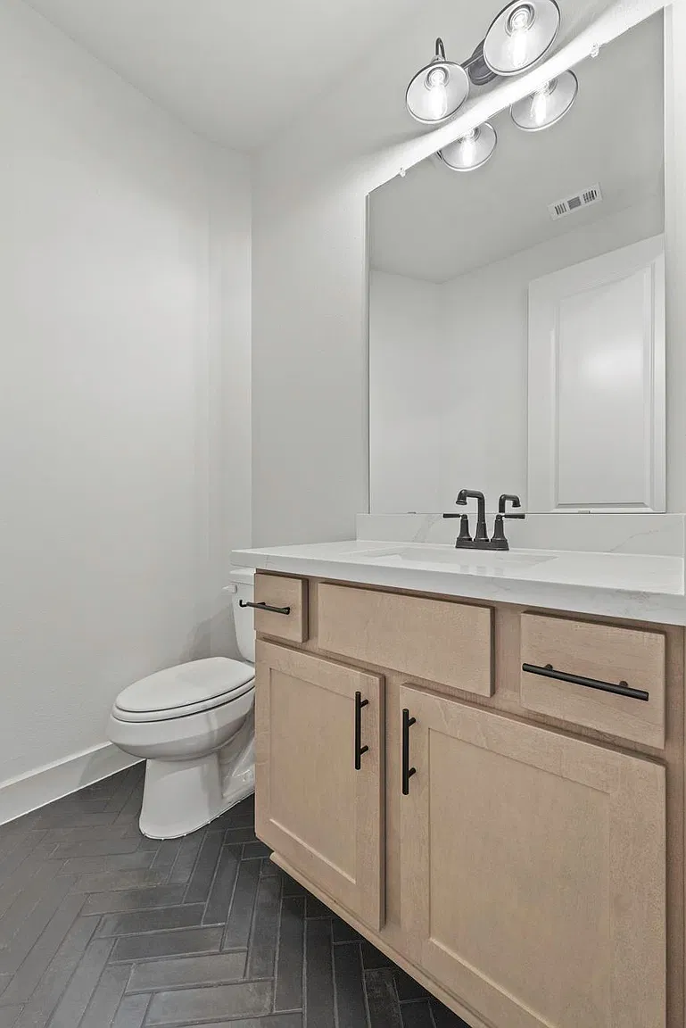 Powder room with light wood vanity and large mirror | 配浅木浴室柜和大镜子的一楼半卫